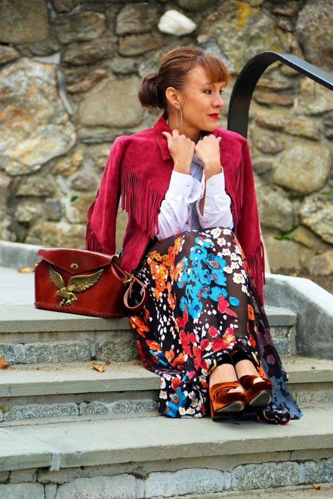 Crimson suede fringe jacket styled with floral maxi skirt and leather bag