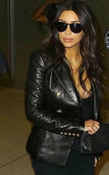 Black leather double-breasted blazer with gold buttons and studded cuffs worn street style