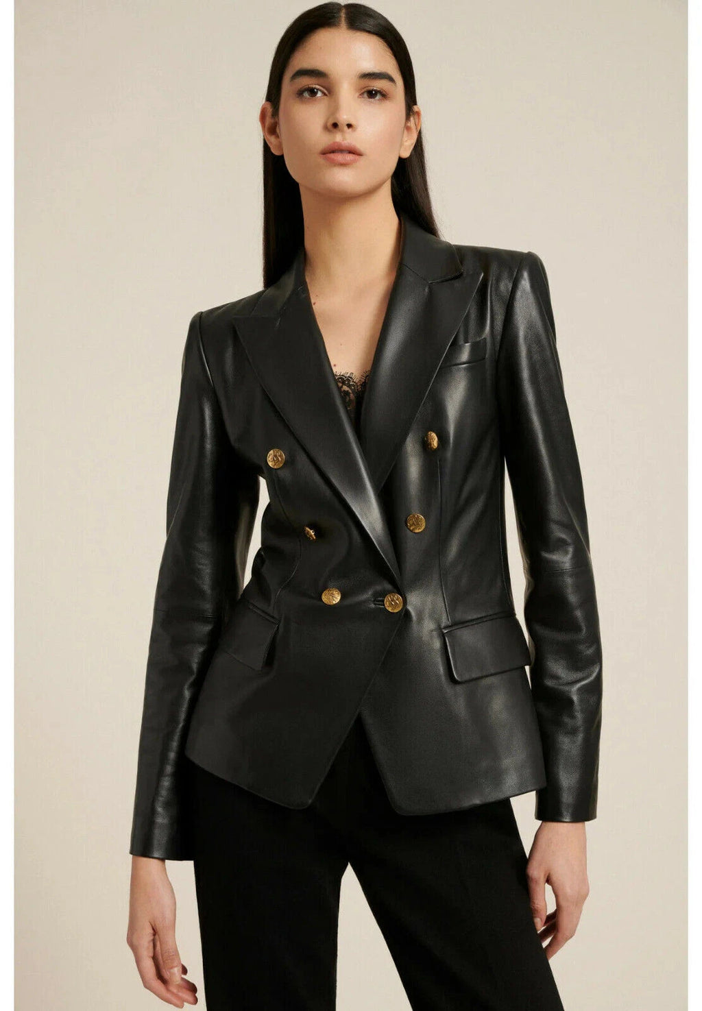 Black leather double-breasted blazer with gold crest buttons and peak lapel on model