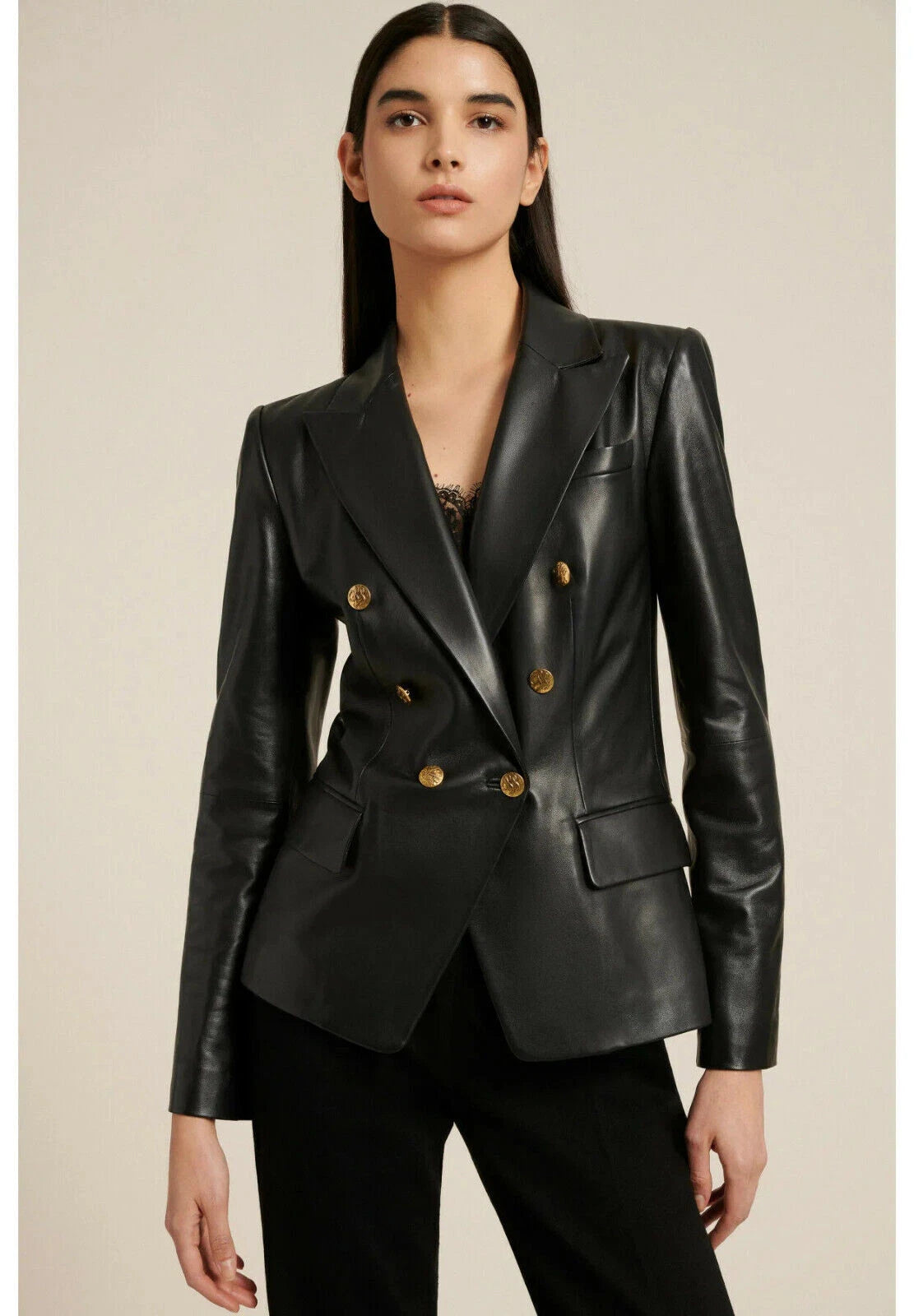 Black leather double-breasted blazer with gold crest buttons and peak lapel on model