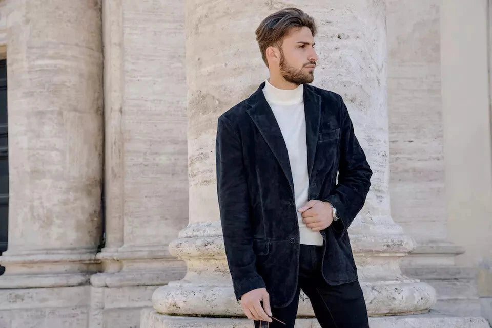 Black textured tailored blazer with notch lapels, two-button closure, chest welt pocket, and front flap pockets