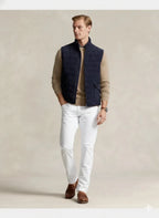Front view of a navy quilted zip-front vest with a stand collar and two front pockets