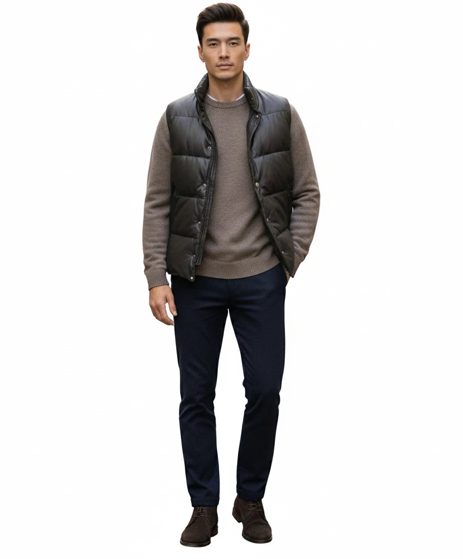 Front view of black horizontally quilted sleeveless puffer vest on model