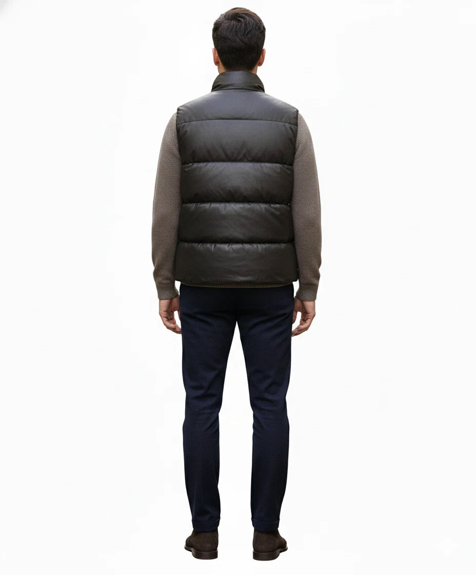 Back view of black horizontally quilted sleeveless puffer vest on model